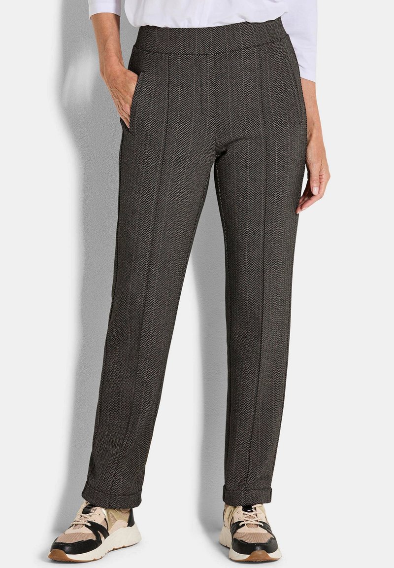 Grijze houndstooth broeken met een hoge taille, zijzakken en een taps toelopend model, gecombineerd met beige en zwarte sneakers met veters en accenten.
