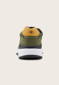 Sneaker con tomaia in pelle verde, linguetta in suede gialla sul tallone, suola intermedia bianca e suola esterna in gomma nera testurizzata. Design semplice senza motivi.