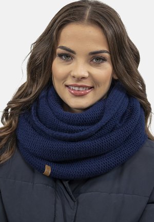Námořnický pletený šál s výraznou texturou a smyčkovým designem, doplněný malou koženou etiketou na boku.