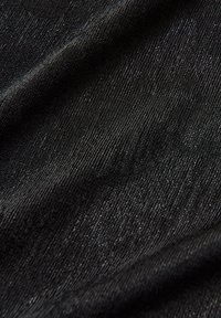 Tessuto elastico nero con una superficie texturizzata, caratterizzato da una lieve lucentezza. Il materiale appare liscio e morbido, adatto per capi d'abbigliamento.