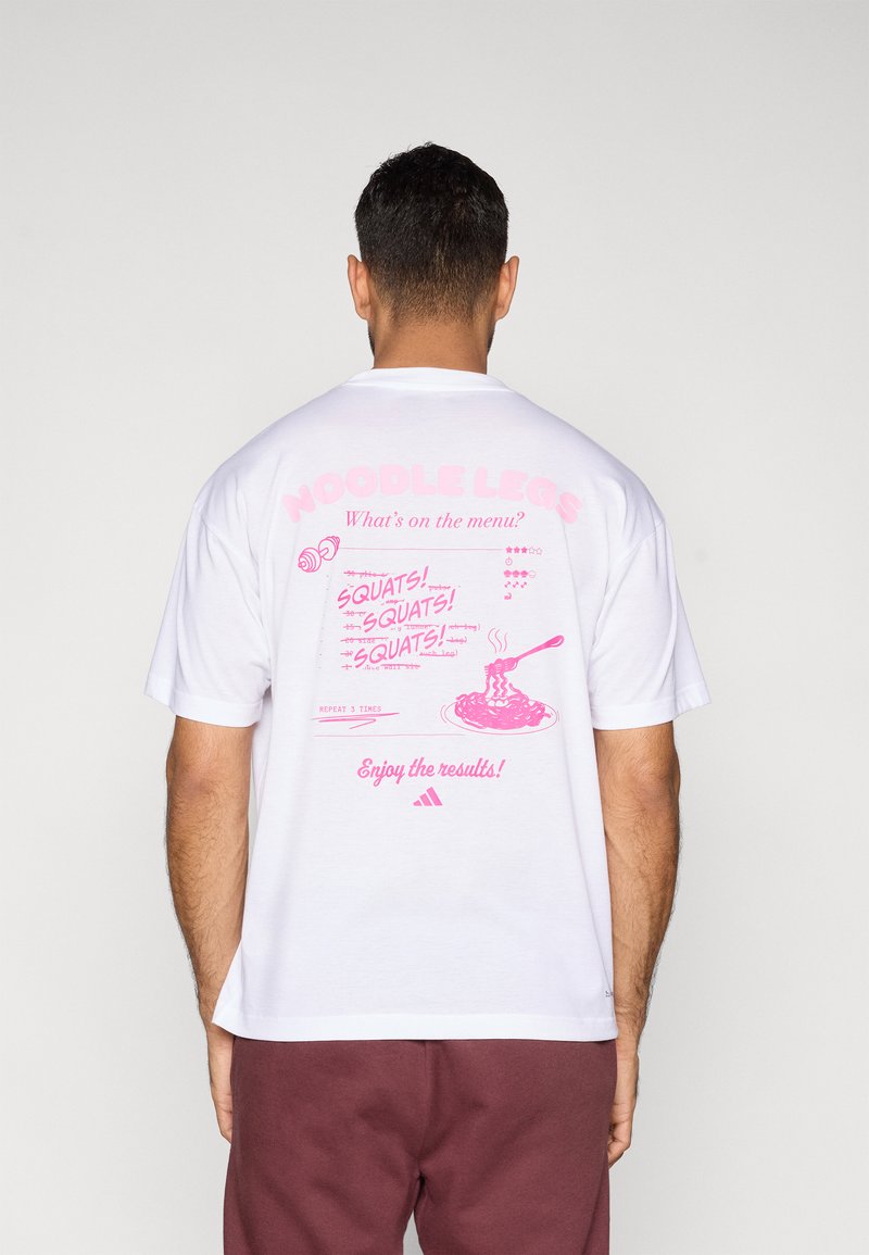 Biele bavlnené tričko s veľkým ružovým motívom na zadnej strane, ktorý obsahuje text a ilustrácie súvisiace s fitnesom a humorom.