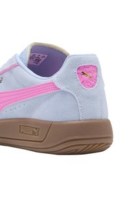Zapatilla de ante azul claro con acentos rosas, que presenta un parche de logo texturizado, suela de goma y costuras en contraste.