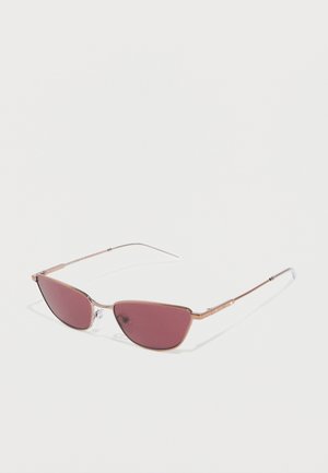 Lunettes de soleil à monture métallique fine avec des verres rectangulaires étroits teintés de rose et des plaquettes de nez ajustables sur un fond blanc uni.