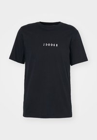T-shirt nera a maniche corte in cotone, caratterizzata da una grafica bianca distorta "JORDAN" sul davanti. Design classico con scollo a girocollo.