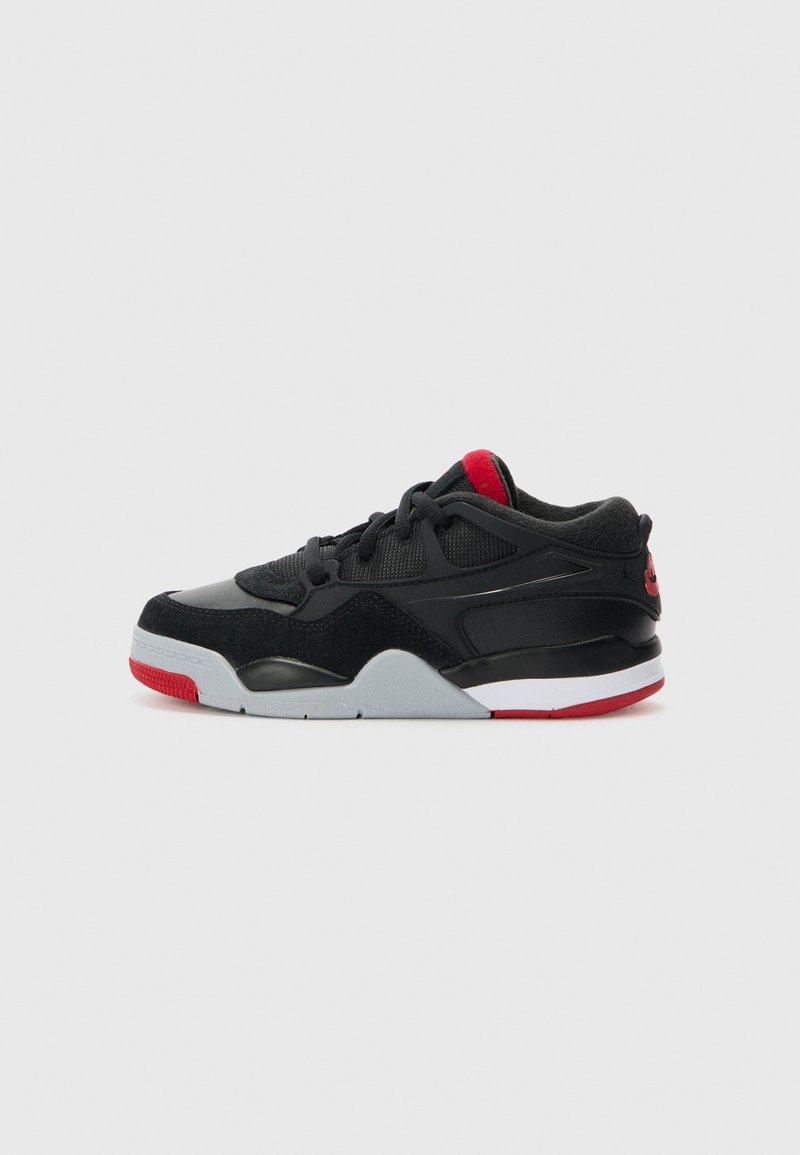 Chaussure de sport noire et grise avec un haut en suède et en mesh, des accents rouges sur la languette et la semelle, et une semelle intermédiaire blanche. Design sportif classique.