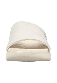 Cream-colored slide sandal with a smooth, matte texture, wide strap across the foot, and a textured rubber sole.