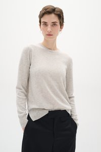 Light gray wool sweater with a crew neck, long sleeves, and ribbed cuffs. Paired with black tailored pants featuring a flat waistband.