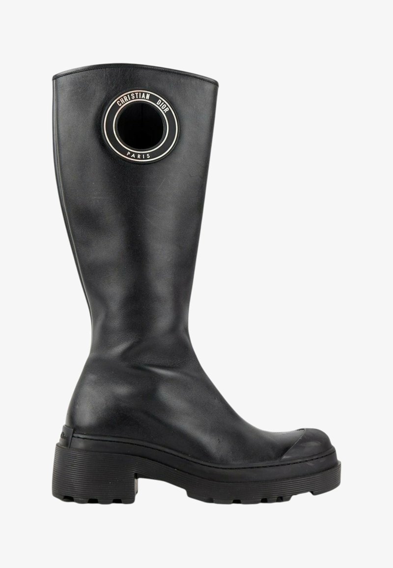 Botte noire en cuir montant jusqu'au genou avec semelle épaisse et découpe ronde près du sommet avec la marque "Christian Dior Paris".