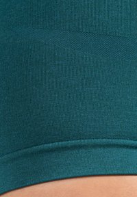 Teal sportieve crop top met een geribbelde textuur en een gladde zoom. Heeft een subtiel logo en een aangesloten ontwerp voor comfort.