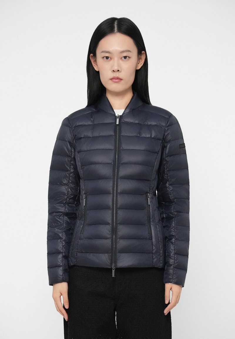 Ναυτικό πλύσιμο μπουφάν με οριζόντιες ραφές, μπροστινό φερμουάρ και δύο πλαϊνές τσέπες. Ελαφρύ, κομψό σχέδιο με όρθιο γιακά και ελάχιστους μεταλλικούς εξαρτήματα.