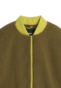 Fleece bomberjack in olijfgroen met een smooth, heldergele kraag. Voorzien van drukknoopsluiting en textiel met structuur.