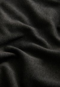 Tessuto nero con una texture liscia, caratterizzato da leggere pieghe e piegature. Il materiale appare morbido e leggero.