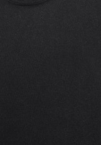 Plain black crew-neck t-shirt fabric showing detailed texture and stitching at the neckline.