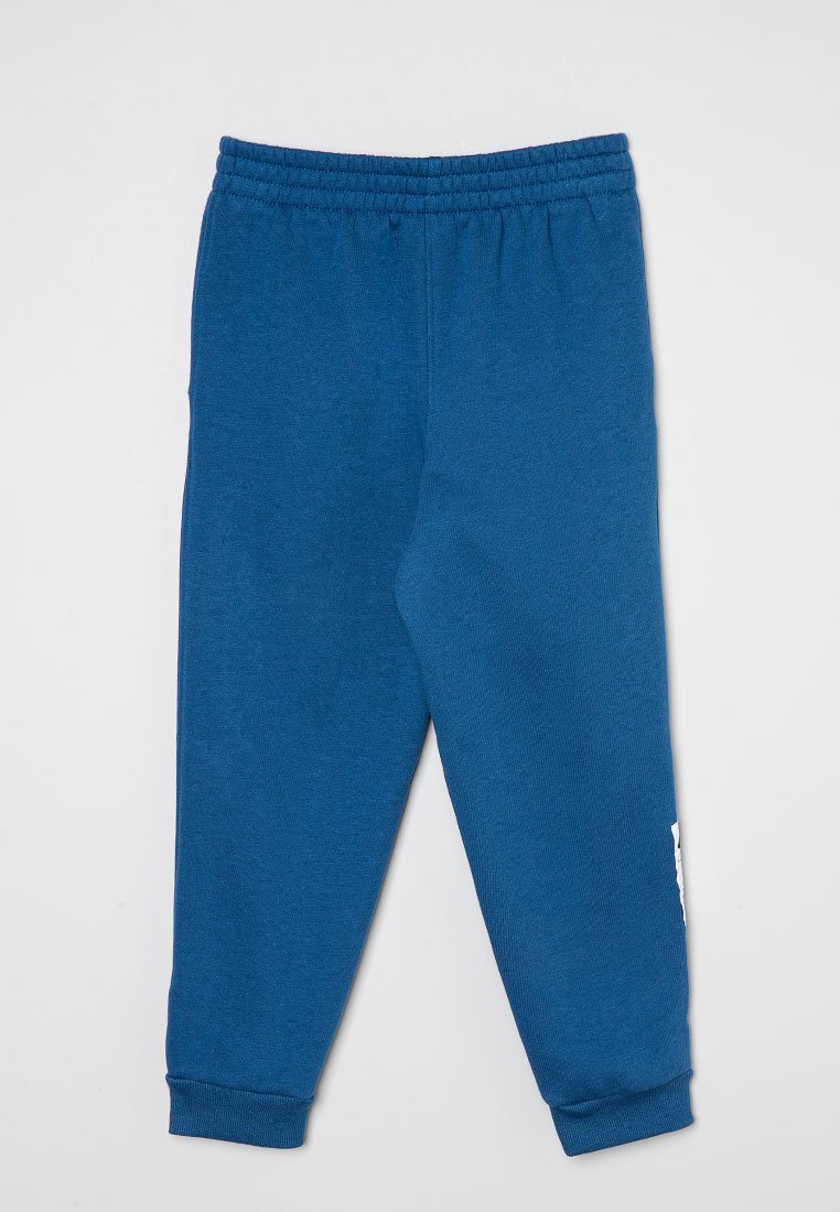 Pantalones de chándal azules de tela suave, con cintura elástica, tobillos ajustados y un detalle de logo blanco en el lado izquierdo.