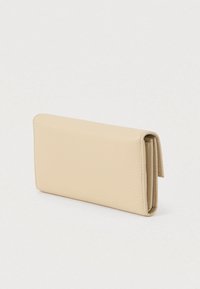 Αυτός είναι ένας μπεζ δερμάτινος πορτοφόλι με υφή και τριπλό σχεδιασμό, που απεικονίζεται κλειστός και όρθιος πάνω σε λευκή επιφάνεια.