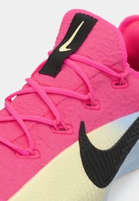 Ροζ αθλητικό παπούτσι με υφασμένο επάνω μέρος, μαύρο λογότυπο και αντίθετη λαστιχένια σόλα. Διαθέτει έντονα ροζ κορδόνια και μαύρο συγκρατητήρα κορδονιών.