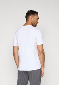 Hvid kortærmet t-shirt med rund hals, lavet af let og glat stof. Har en almindelig pasform og et enkelt design uden mønstre.