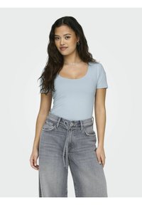 Lys blå tettsittende topp med rund hals, paret med høyt midje grå vide bukser med snor-detalj og synlige sømmer.