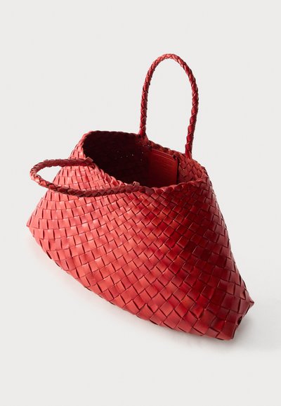 Κόκκινη πλεκτή δερμάτινη τσάντα με δύο πλεκτές λαβές, τραπεζοειδούς σχήματος και ανοιχτό πάνω μέρος, απεικονιζόμενη σε λευκό φόντο.