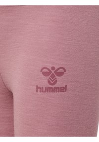 Hummel leggings van zacht, gewatteerd lichtroze stof, met een donkerroze logo gedrukt op het onderbeen. Gladde, strakke pasvorm.