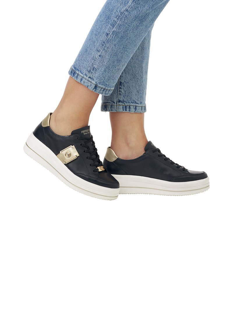 Schwarze Ledersneakers mit goldenen Akzenten und dicken weißen Sohlen. Verfügt über ein Schnürdesign und strukturierte Details an den Seiten.