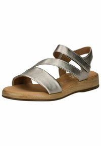 Sandalo argento metallico con due cinturini incrociati, punta aperta e soletta morbida. Caratterizzato da una suola in legno a bassa texture per il comfort.