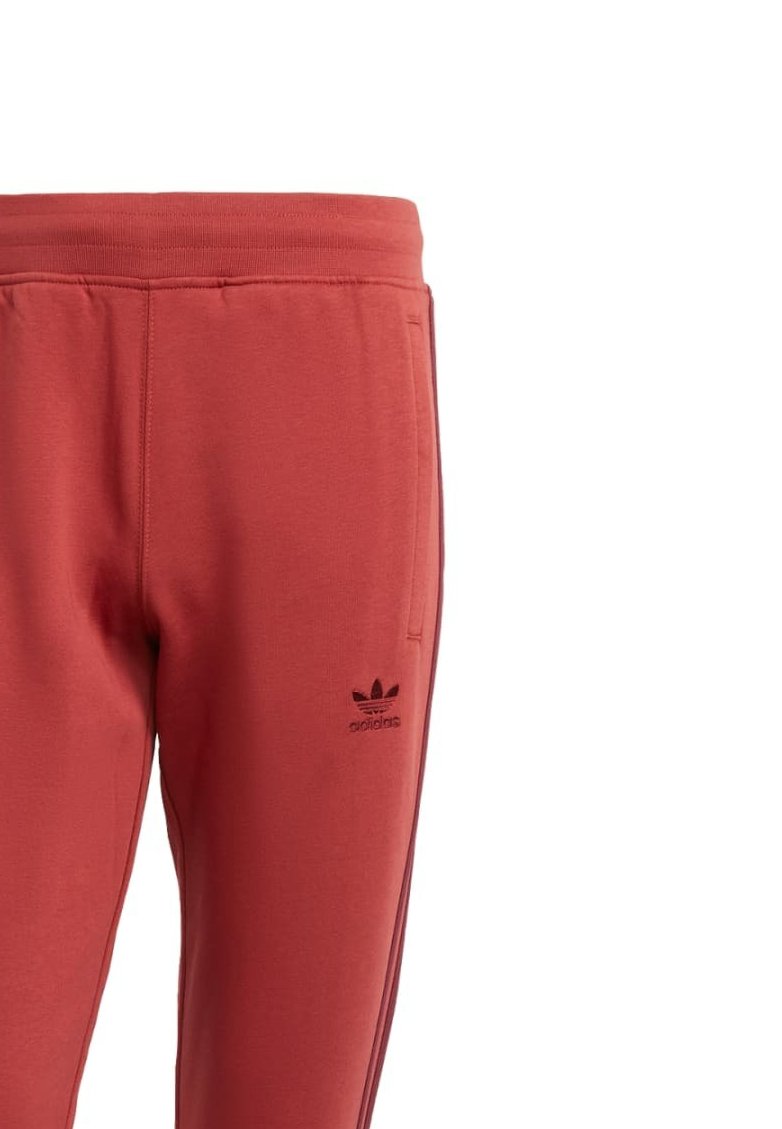 Rote Jogginghose mit schwarzem Adidas-Logo, elastischem Bund, seitlichen Taschen und kontrastierendem Streifen entlang der Außennaht. Material aus Baumwollmischung.