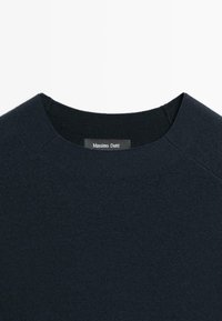 Marineblauwe gebreide sweater met een ronde halslijn en een zachte textuur. Het etiket toont "Massimo Dutti" aan de binnenkant.