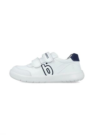 Zapatillas deportivas blancas con un upper de cuero liso, dos correas de velcro, acento en el talón en color marino y logo negro en el lateral. Suela de goma con patrón de tracción.