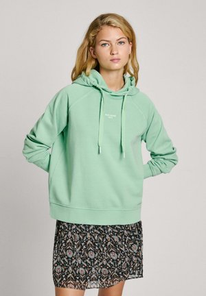 Mintgroen hoodie met een voorzak in kangoeroestijl, geribbelde manchetten en een zoom, gelaagd over een zwarte rok met bloemenprint.