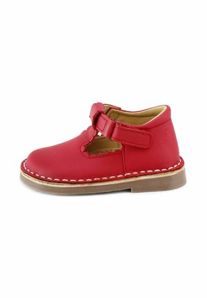 Zapato infantil de cuero rojo con correa ajustable, borde recortado con forma de concha, costuras blancas y suela beige sobre fondo blanco.