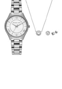 Zilveren Michael Kors horloge met Romeinse cijfers, kristallen lunette, bijpassende kristallen hangero ketting en twee paar oorstekers op witte achtergrond.