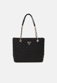 Black quilted tote bag with dual black handles and chain accents. Features a gold triangular logo at the front. Textured leather surface.