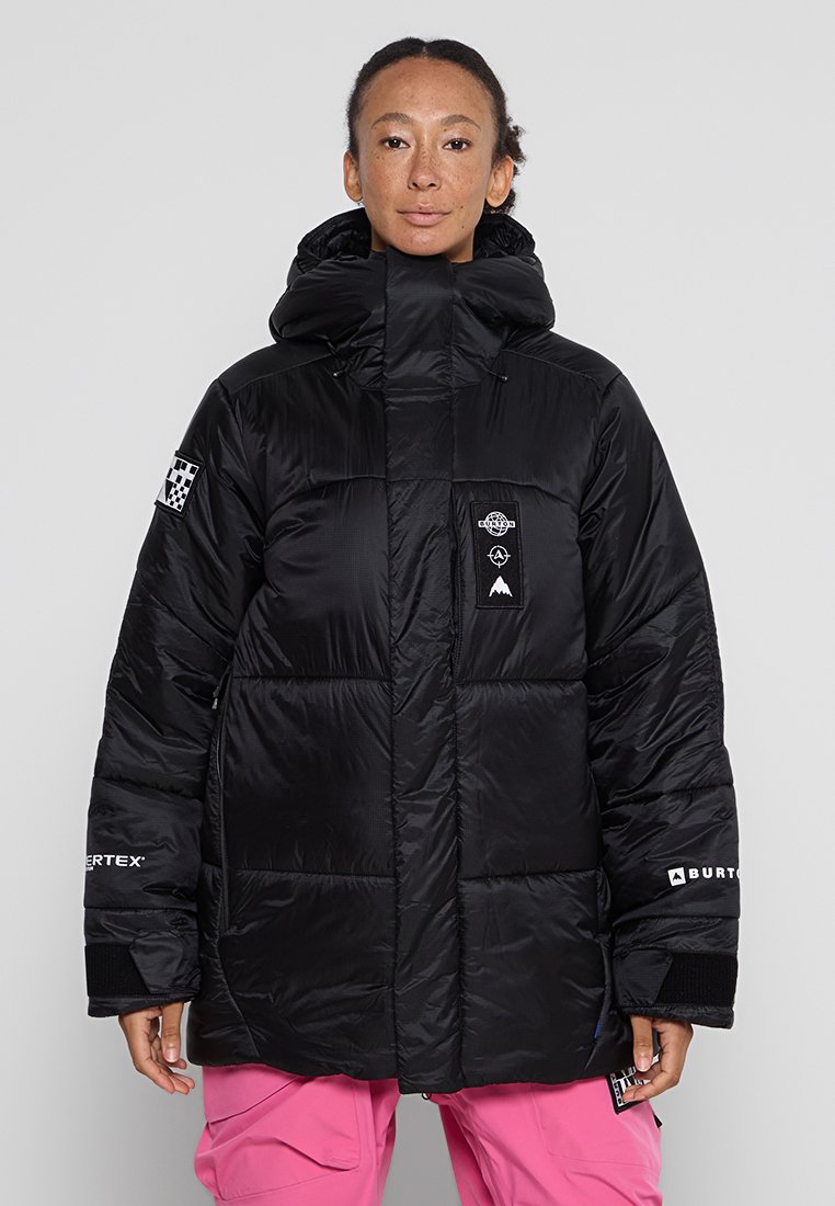 Schwarze Daunenjacke mit hohem Kragen, aufgesetzten Taschen und Logo-Details. Hergestellt aus leichtem, strukturiertem Stoff mit gestepptem Design.