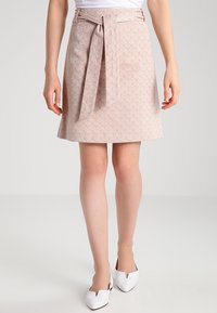 Gonna rosa chiaro con un motivo geometrico, dotata di una cintura in vita e di una forma strutturata. Il tessuto appare liscio con una finitura leggermente testurizzata.