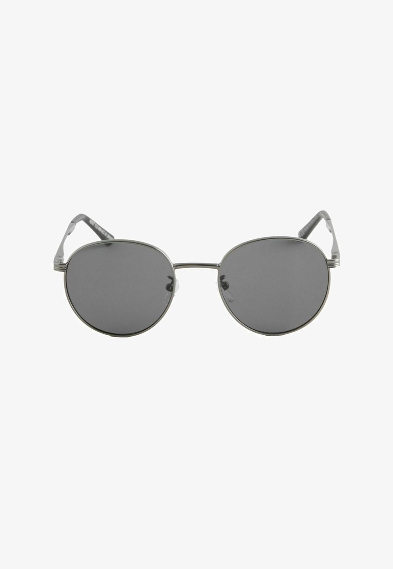 Lunettes de soleil rondes avec verres foncés, monture fine en métal argenté et plaquettes de nez, vues de face sur un fond blanc.