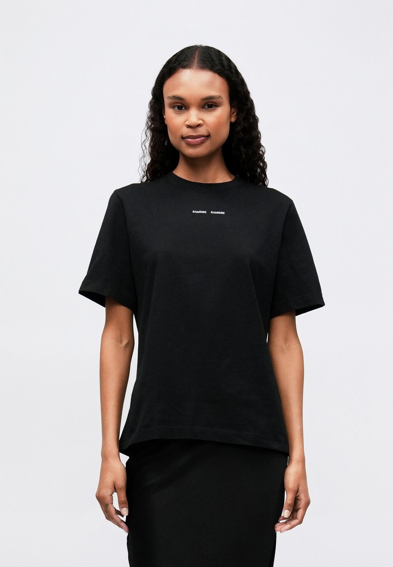 Black cotton t-shirt with short sleeves, round neckline, and a subtle white logo on the chest. Relaxed fit; smooth texture.