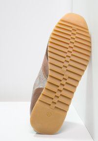 Hnědé tenisky s texturovaným svrškem, se vzorovaným designem a gumovou podrážkou. Velikost 37 je označena na spodní straně.