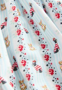 Tissu en coton avec un motif rayé bleu clair, agrémenté de petites images de chiens et de roses rouges, sur un fond doux et texturé.