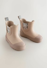 Cizme bej din cauciuc cu finisaj texturat, vârf rotunjit și căptușeală interioară cu model de ursuleți. Include o buclă pentru a fi ușor de purtat.