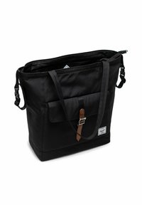 Sac fourre-tout noir avec poche frontale à rabat, sangle brune avec boucle, poignées doubles, fermeture éclair sur le dessus et clips latéraux sur fond blanc.