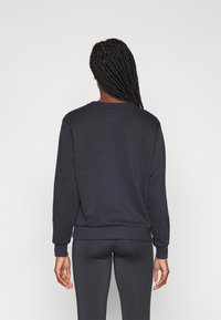 Mørkegrå hettegenser med lange ermer, rund hals, ribbestrikkede mansjetter og nederkant. Stoffet ser mykt ut, med et enkelt og rent design.