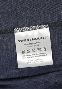 Dark blue fabric with a smooth texture and a care label stating 60% Merino Wool and 40% Tencel with washing instructions.