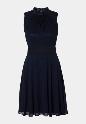 Laivansininen ilman hihnoja oleva mekko, jossa on poimutettu pääntie, istuva vyötärö ja liehuva hame. Sisältää koristeellista yksityiskohtaa pääntiellä.