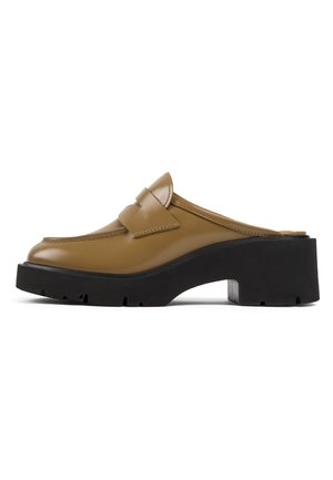 Chaussure en cuir marron à enfiler avec un bout arrondi, un avant surélevé et une semelle plateforme noire épaisse. Détails de couture et accent de bandeau sur le dessus.