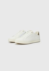 Sneakers bianchi in pelle con punte arrotondate, accenti testurizzati, dettagli in oro sui passanti e suola in gomma marrone a contrasto.