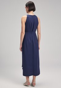 Navy blue sleeveless maxi dress with a fitted bodice and flared skirt, featuring a keyhole back and side slits. Smooth fabric texture.