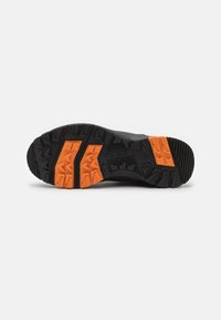 Černá sportovní bota s oranžovými gumovými akcenty, vybavená texturovaným, vícesměrným vzorem podrážky pro trakci a odolnost.