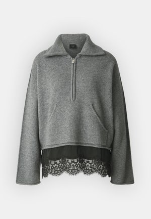 Grå, langærmet pullover lavet af tekstureret stof, med en halvlange lynlås, forlomma og en sort blondesøm forneden.