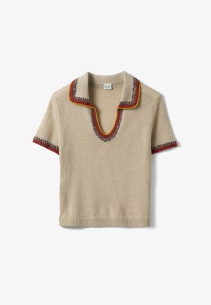 Maglia beige a maniche corte con collo aperto, caratterizzata da cuciture decorative rosse, marroni e gialle lungo il collo, la scollatura e i bordi delle maniche.